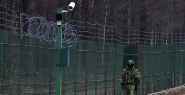 Білоруський прикордонник біля обладнаного камерами паркану з колючим дротом на кордоні з Україною (Фото: Reuters)